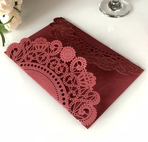 Detailed laser-cut burgundy invitation card with elegant lace floral pattern on pearl paper