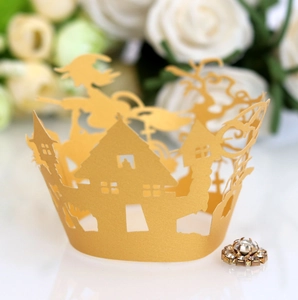 Macro view of laser-cut witch castle cupcake wrapper in matte gold for Halloween