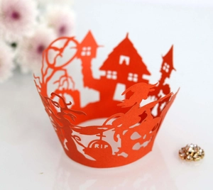 Detail of red laser cut cupcake wrapper with Halloween castle and bat hollow designs