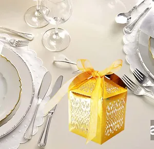 Laser-cut gold party favors box with elegant vine patterns and a silk ribbon bow