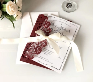 Burgundy laser-cut wedding invitation set with white ribbon and printed inner card