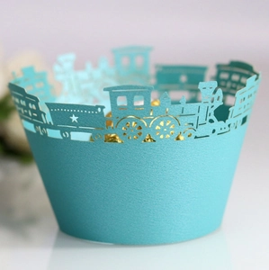 Detail of light blue laser-cut train cupcake wrappers with hollow star patterns