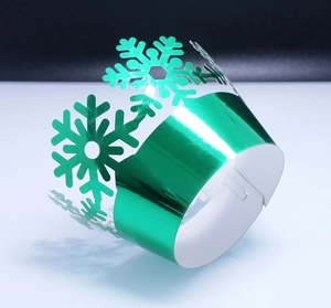 Green metallic cupcake wrapper with laser-cut snowflake design and secure buckle closure