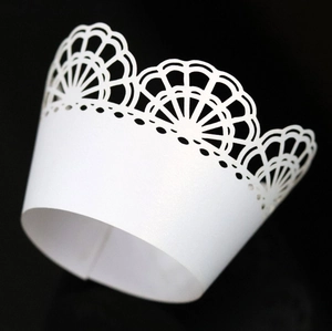 Close-up of laser-cut white lace cupcake wrapper with elegant pearlescent finish