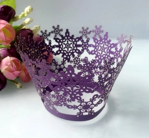 Intricate laser-cut snowflake cupcake wrapper in deep purple for elegant holiday baking