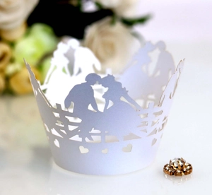 Intricate laser-cut white wedding cupcake wrapper featuring romantic couple silhouettes