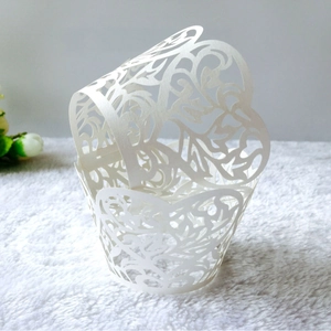 Intricate laser-cut white flower lace cupcake wrappers for wedding and party decorations