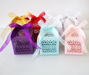 Detailed laser-cut gift boxes in multiple colors with organza ribbons for weddings