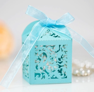 Close-up of light blue laser-cut candy box with intricate patterns and ribbon bow