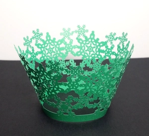 Detail of laser-cut green snowflake hollow cupcake wrappers for Christmas parties