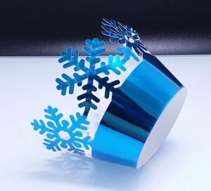 Macro view of blue reflective cupcake wrappers with laser-cut snowflake patterns