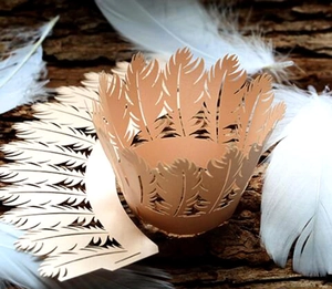 Laser-cut feather pattern cupcake wrappers in light orange for elegant party decor