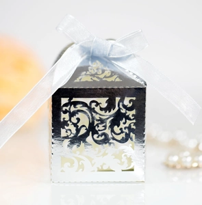 Close-up of silver laser-cut lace candy box with light blue silk ribbon and bow