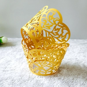 Yellow laser-cut cupcake wrappers with hollow heart patterns for birthday party decor