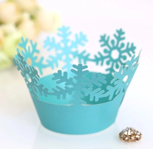 Close-up of laser-cut sky blue cupcake wrappers with hollow snowflake patterns for winter decor
