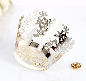 Close-up of silver hollow snowflake crown cake topper with laser-cut metallic details
