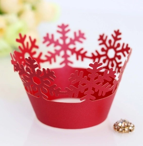 Detail of red hollowed-out snowflake cupcake wrapper with laser cut Christmas pattern