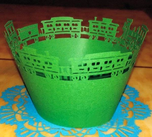 Detailed laser-cut train pattern on green hollowed-out cupcake paper wrappers