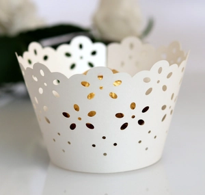 Macro detail of laser-cut floral cupcake wrapper in light blue with elegant hollow pattern