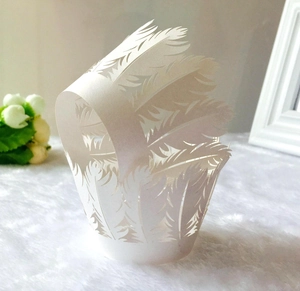 Detailed laser-cut white cupcake wrapper with elegant feather texture for wedding cake decor