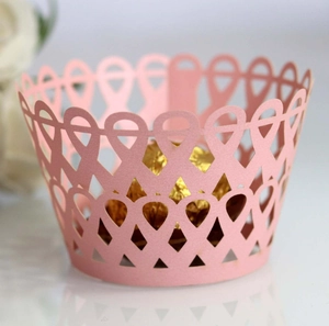 Détail de caissettes à cupcakes en papier rose clair découpées au laser à motifs