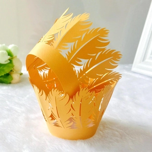 Detailed laser-cut golden feather pattern cupcake wrappers for wedding decorations