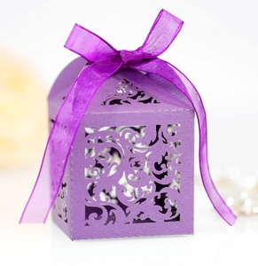 Detailed laser-cut filigree pattern on a purple wedding candy box with silk ribbon bow