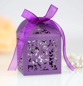 Detailed close-up of a laser-cut purple gift box with ribbon and elegant hollow patterns