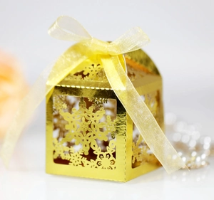 Detail of laser-cut gold snowflake gift box with a delicate yellow organza ribbon bow