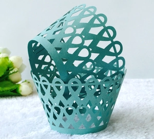 Caissettes à cupcakes découpées au laser vert menthe avec bords à fleurs sur fourrure blanche