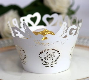 Elegant white laser-cut wedding cake wrappers with gold foil hearts and birds