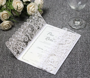 Macro detail of laser-cut white lace wedding invitation with elegant floral hollow patterns