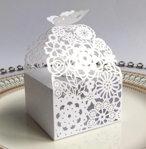 Elegant white laser-cut butterfly gift box with floral patterns on a porcelain plate