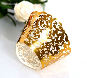 Detailed laser-cut golden vine pattern cupcake wrappers for wedding cake decorations