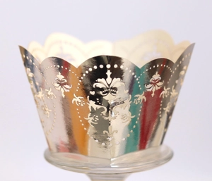Elegant champagne gold laser-cut lace cupcake wrappers with intricate floral patterns