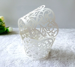 Elegante lasergesneden witte cupcake wrapper met rankenpatroon op zacht pluche