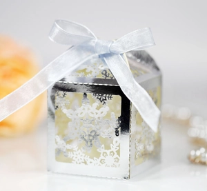 Detail of silver laser-cut snowflake gift box with blue ribbon and satin bow