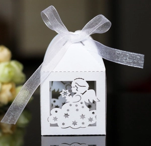 Detailed laser-cut white favor box featuring an angel and star pattern with white ribbon