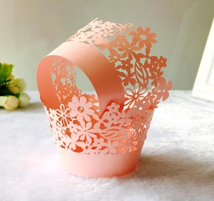 Detail showing pink laser-cut floral cupcake wrapper with pearl finish for weddings