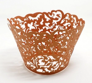 Detailed laser-cut bronze cupcake wrapper with intricate floral vine patterns