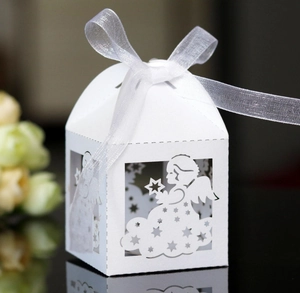 Detail of white laser-cut angel gift box with stars, clouds and a silver ribbon bow