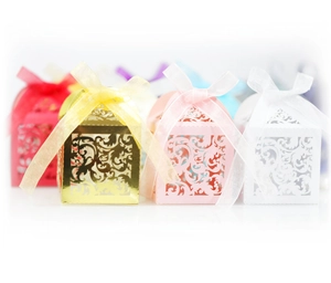 Close-up of laser-cut hollow candy boxes in gold, pink, white and red with ribbons