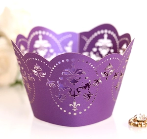 Detail of laser-cut crown pattern on dark purple cupcake wrapper for wedding decor