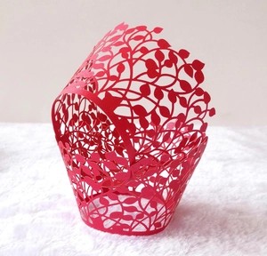 Detailed laser-cut vine and leaf pattern on red paper cupcake wrapper for parties
