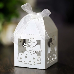 Detailed laser-cut white favor box featuring angel patterns and a satin ribbon bow