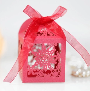 Detailed laser-cut snowflake hollow gift box with red organza ribbon and bow tie