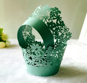 Detailed laser-cut floral pattern on dark green pearlescent paper cupcake wrapper