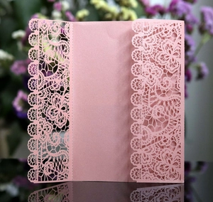 Detailed laser-cut floral lace pattern on elegant pink pearlescent paper invitation cover
