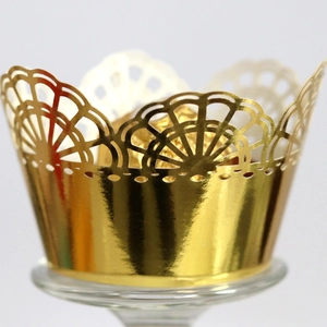 Elegant gold hollow cupcake wrapper with intricate lace laser-cut design for weddings