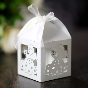 Detail of laser-cut angel baby shower favor box with white ribbon and star patterns
